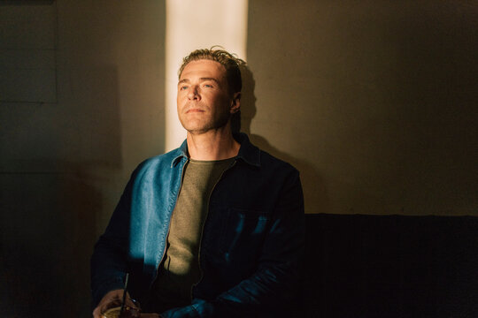 Depressed man contemplation while reclining on wall