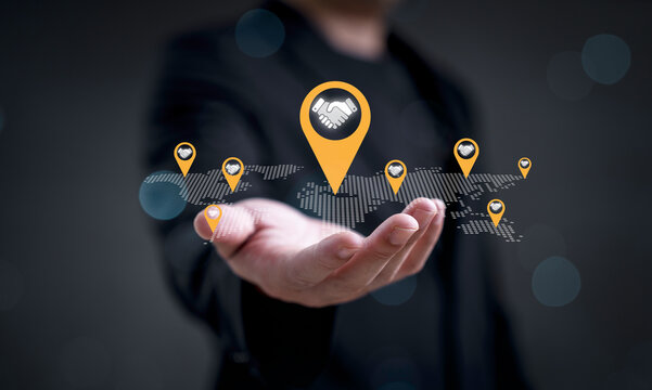 Business partnership concept showing global deal and agreement with handshake icons on world map for symbol of international collaboration, corporate networking, strategic alliance trust and success.