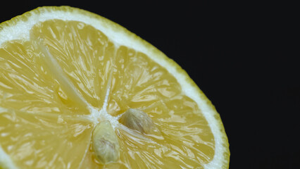 Macro shot of fresh lemon slice on black background
