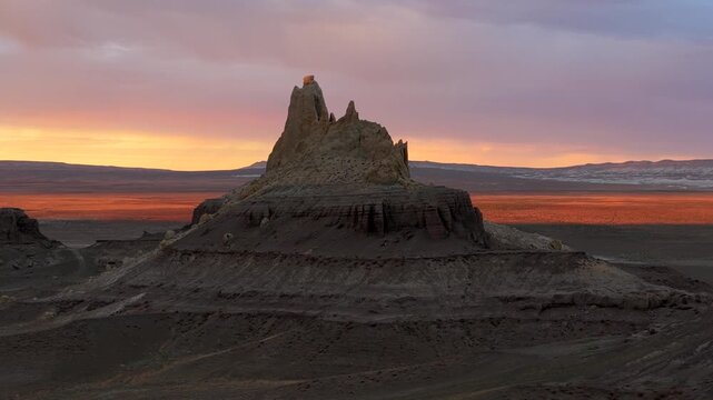 Aerial view of the majestic Airakty Castle amidst the stark landscape, contrasting the warm glow of the setting sun with the cool tones of the rocks, Shetpe, Mangystau Region, Kazakhstan.