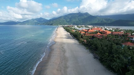 Stunning aerial view of Lang Co Beach featuring golden sand, turquoise ocean, lush resorts, and...
