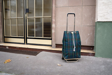 Shopping caddy parked outside a residential building entrance autumn