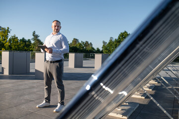 Male standing near solar panels controlling energy system