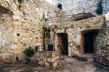 Roquebrune Cap Martin, France - February 9, 2025: Interior courtyard of the medieval Grimaldi Castle with ancient stone well and fortress walls