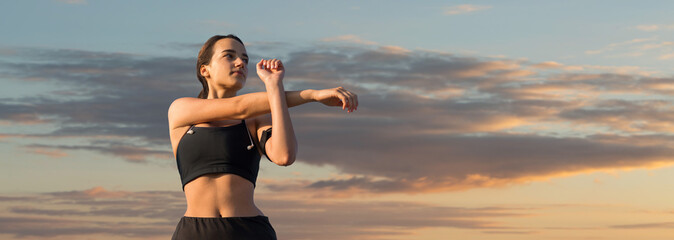 A young slim athletic girl in sportswear performs a set of exercises. Fitness and healthy lifestyle.