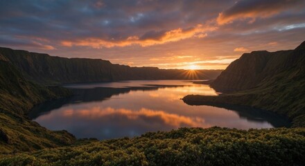 Obraz premium Sunset over a lake nestled in a valley, reflected in still water