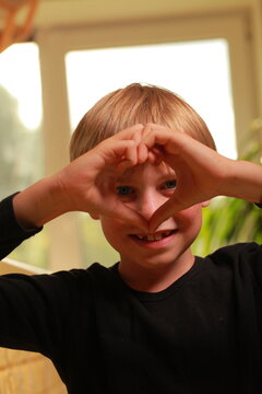 Young boy framing vision with hands, focusing on future
