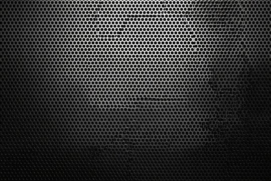 Black perforated metal texture, with many small holes and a gradient of light - Powered by Adobe