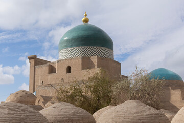 Khiva Uzbekistan Pahlavan Mahmoud mausoleum showing green dome and burial mounds in foreground a Silk Road city © Gary