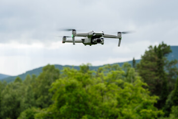 An unmanned aerial vehicle flies in the air low above the ground