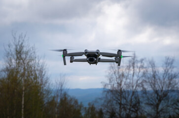 An unmanned aerial vehicle flies in the air low above the ground