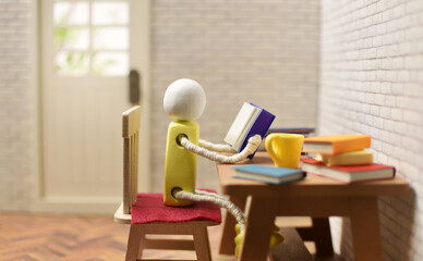 読書をする木製人形の写真　積まれた本　趣味の時間　勉強　ミニチュア