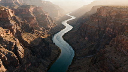 An aerial view of a winding river cutting through a canyon with steep rock walls. travel magazines, destination branding, designed for travel destination branding.