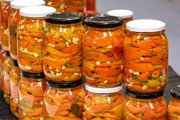 Red pickled peppers inside mason jars in home pantry