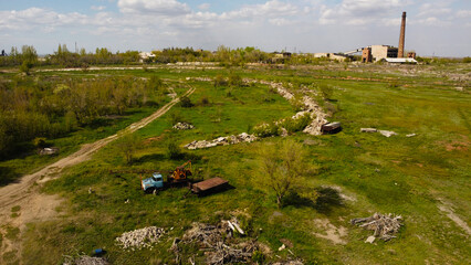 Aerial View of a Derelict Industrial Zone with an Old Blue Crane Truck and Tall Brick Chimney