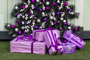 Christmas tree detail with purple ornaments decoration and presents beneath