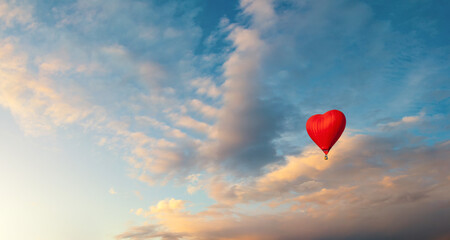 Romantic background with bright red heart shaped balloon flying in the sunset sky, free space for text, suitable for St Valentine's Day