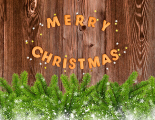 Merry Christmas cookies with stars and branches of spruce on dark wooden background. Christmas or New Year greeting card.
