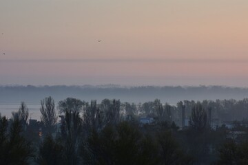 Sunrise over the river in the early morning. Winter fogy landscape