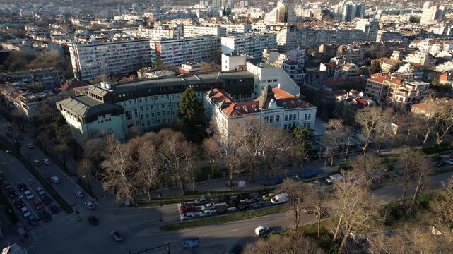 Aerial view of the University of Economics surrounded by urban buildings, roads, and trees, showcasing a blend of education and city life, Varna, Varna, Bulgaria.