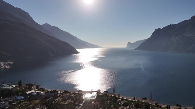 Aerial view of Lago di Garda showing the glistering water contrasting with the dark, towering mountains, Lago di Garda, Trentino-Alto Adige, Italy.
