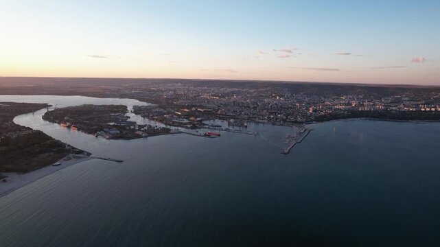 Aerial view of the Varna coastline, where the city meets the sea, showcasing the port and urban landscape under a soft, diffused light, Varna, Varna, Bulgaria.