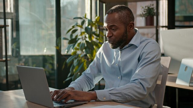 African American 40s business man typing laptop web service cyberspace adult businessman working online at office smiling mature male executive worker manager developer with computer data programming - Powered by Adobe