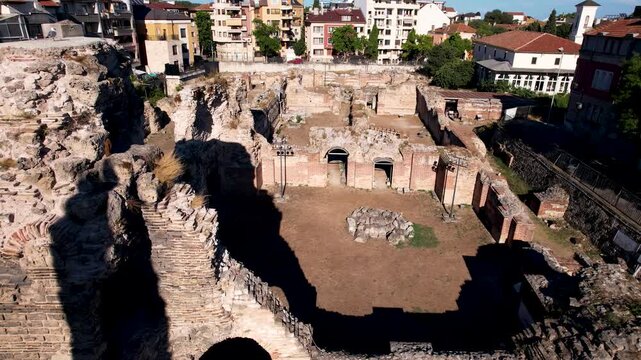Aerial view of the ancient Roman Thermae ruins, contrasting weathered stone with modern buildings, bathed in the warm light of Varna, Varna, Bulgaria.