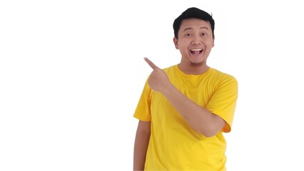 amazed and smiling happy Asian man pointing finger at copy space on left side or right side. Indonesian man pointing finger at advertisement.