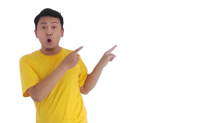 amazed and smiling happy Asian man pointing finger at copy space on left side or right side. Indonesian man pointing finger at advertisement.