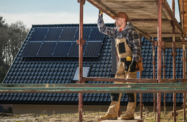 Worker Adjusts Scaffolding During Construction on a Sunny Day