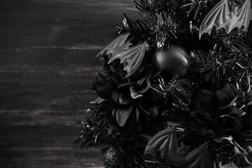 Gothmas. Gothic Holiday Decor. Dark festive wreath with black bats and flowers creating a...