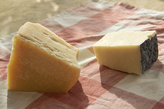piece of parmesan and pecorino romano on rustic cloth with natural light