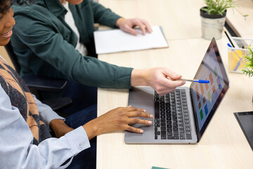 Colleagues collaborating on business data analysis using laptop