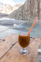 Glass of apricot juice above Hussaini Suspension Bridge in Hunza valley, Gilgit-Baltistan region of Pakistan