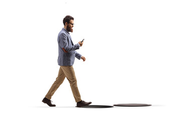 Fototapeta premium Man looking at his mobile phone about to fall in an open manhole shaft