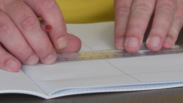 Drawing red lines in a notebook using a ruler to create straight edges during a creative session