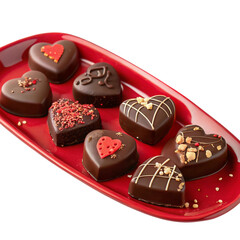 dark chocolate heart shaped candies on red serving tray with intricate designs