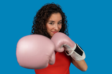 Woman boxer wearing pink gloves on blue background