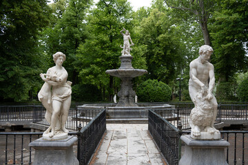 Elegant fountain with marble statues in a lush garden