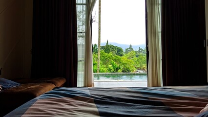 Cozy bedroom view overlooking tropical pool and lush greenery, perfect relaxing holiday escape