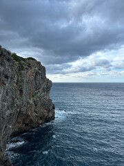 Rocky Coastline and Open Sea on Mallorca.
Rocky cliff coastline with deep blue sea and cloudy sky on Mallorca island.