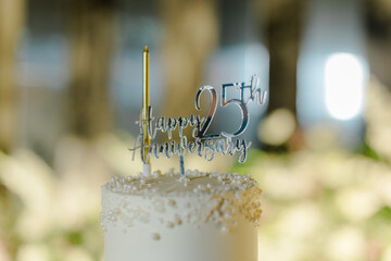Celebrating 25 years of love! A delicious anniversary cake adorned with a 'Happy 25th Anniversary' topper and a shimmering candle, marking a special milestone. Cheers to the happy couple!