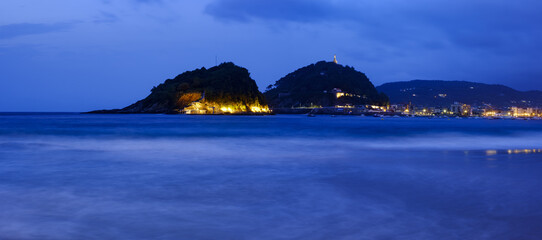 Santa Clara Island from Ondarreta Beach. La Concha Bay at dusk, city of Donostia - San Sebastian, Basque Country
