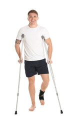 Man with hurt leg and crutches on white background