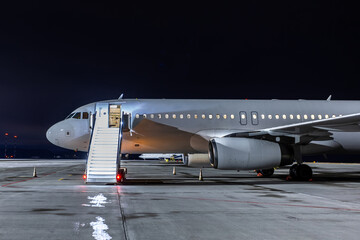 Passenger airliner with stairway at the night airport