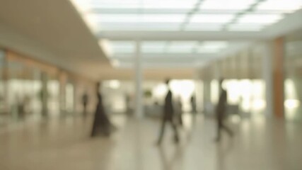Blurred view of busy modern office lobby with people walking. Represents the hustle and bustle of corporate life and professional environments