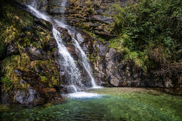 Naklejka premium A waterfall and a small water pond full of clean water on the way to Namche bazaar town. Everest base camp trek, Nepal.