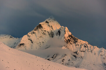 Snowy Mt. Ama Dablam at sunset and dark stormy cloud behind it. View from Thokla (Dughla), Everest base camp trek, Nepal.