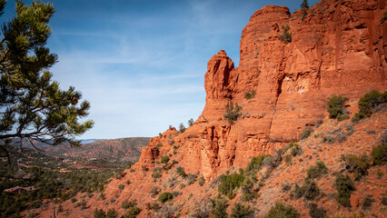 View of rugged red rock formations under a clear blue sky create a striking contrast against the sparse desert vegetation, Arizona Desert, Arizona, United States.